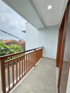 Balkon modern dengan railing kayu di apartemen Sanur, Denpasar Selatan.