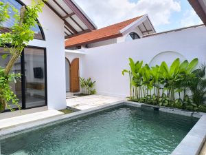 Kolam renang pribadi dekat Canggu, Bali, dengan taman hijau dan suasana tenang.