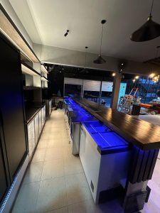 Interior bar modern di Canggu dengan pencahayaan biru dan suasana nyaman.