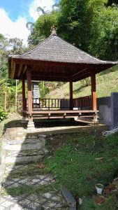 Gazebo kayu tradisional di taman rumah mewah dengan pemandangan gunung dan danau Bedugul.