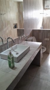 Kamar mandi modern dengan wastafel dan toilet, pemandangan indah Gunung dan Danau Bedugul.